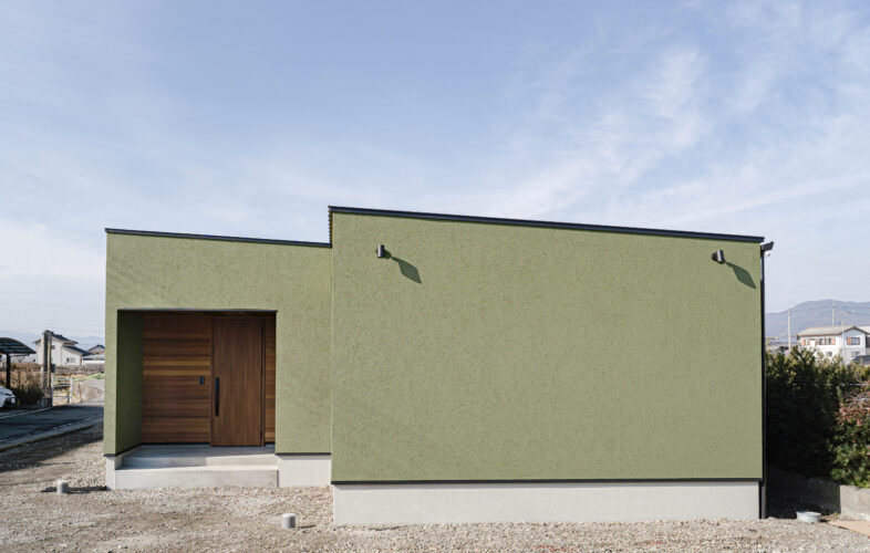 「オリーブグリーンの塗り壁と中庭がつくる光と陰影の平屋。ビルトインガレージを備えたシンプルモダン住宅」